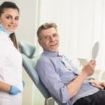 gentleman in dental chair with hygienist