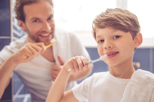 boy and dad brushing their teeth